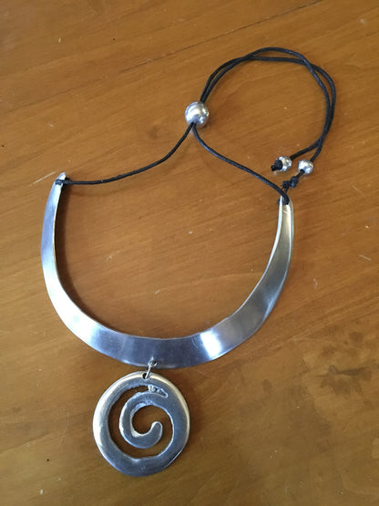 Adjustable aluminum necklace with spiral pendant.